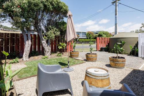 a patio with a table and chairs and an umbrella at Waimarama Coastal Getaway in Waimarama