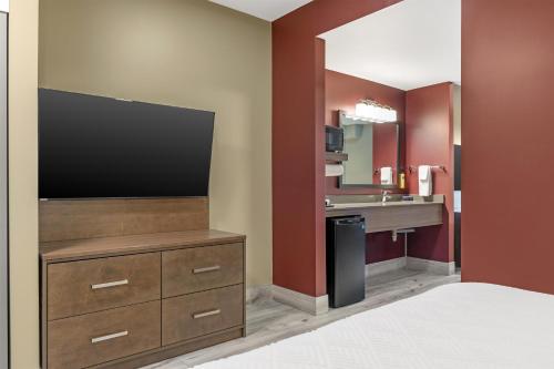 a hotel room with a flat screen tv and a bathroom at Best Western Plus Dauphin in Dauphin