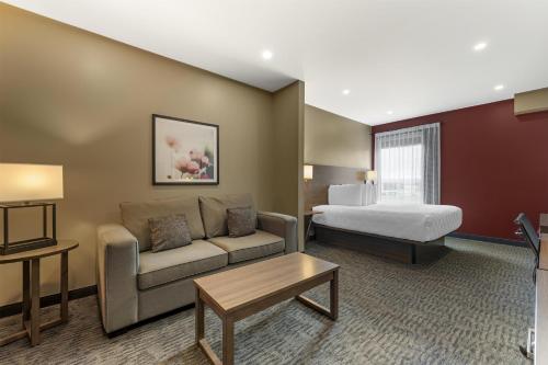 a hotel room with a couch and a bed at Best Western Plus Dauphin in Dauphin