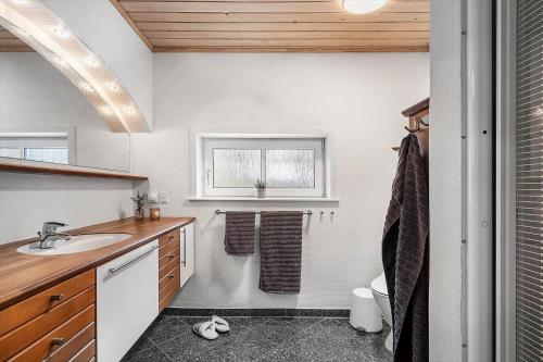 a bathroom with a sink and a toilet and a window at 8848-Hvide-Sande-Numitvej-9 in Hvide Sande