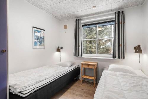 a bedroom with two beds and a window at 8848-Hvide-Sande-Numitvej-9 in Hvide Sande