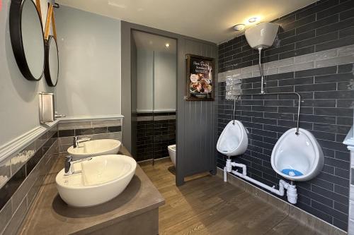 a bathroom with two sinks and two urinals at Lobster Sheringham in Sheringham