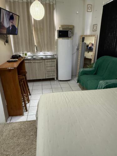a room with a kitchen with a refrigerator and a table at KITNETS Kretzer Hinckel 1 - CENTRO in Alfredo Wagner