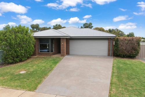 a house with a garage in a yard at 28 Skye Ave - Skye High on Style in Moama