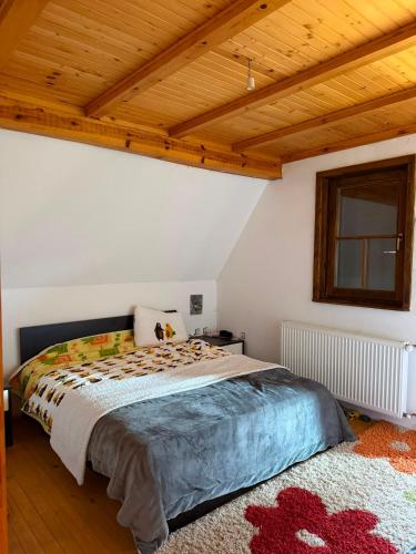 a bedroom with a bed and a wooden ceiling at Winter Dream Vlašić in Šišava