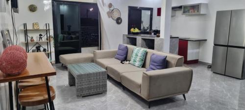 a living room with a couch and a table at Kër Mouna MJN Hotels in Diass