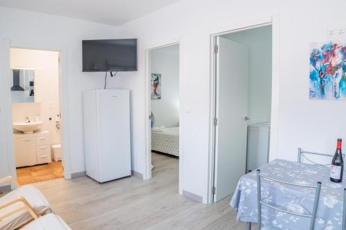 a white room with a white refrigerator and a bedroom at Apartamento Aira 2 in Villadepalos