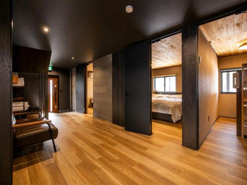 a large room with a bed and a wooden floor at Jaune Chalet in Hakuba