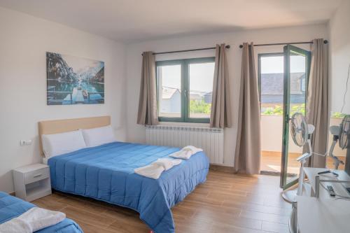 a bedroom with a blue bed and a window at Habitaciones Aira in Villadepalos