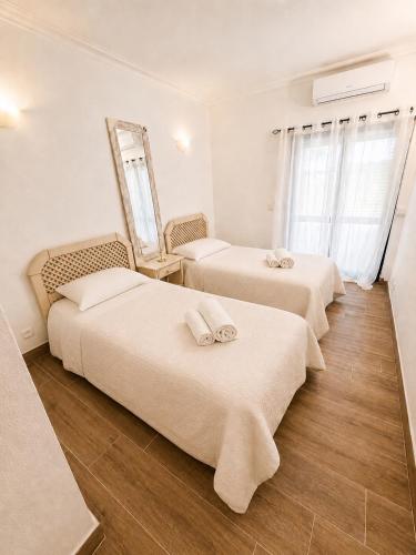 a room with three beds with towels on them at Casa Mar by Living & Co in Albufeira