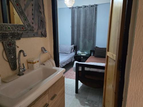 a bathroom with a sink and a room with a bed at Hobbiton in Agadir