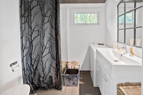 a bathroom with a black shower curtain with a sink at 8221-Vordingborg-Gogeurtvej-13 in Vordingborg