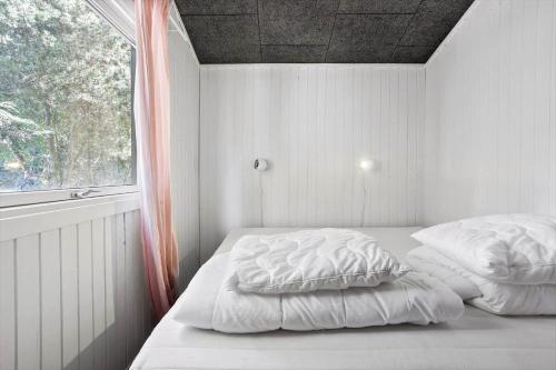 a bedroom with two pillows on a bed with a window at 8221-Vordingborg-Gogeurtvej-13 in Vordingborg