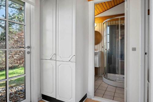 a bathroom with a door leading to a bathroom with a tub at 1087-Stege-Berberisvej-7 in Stege