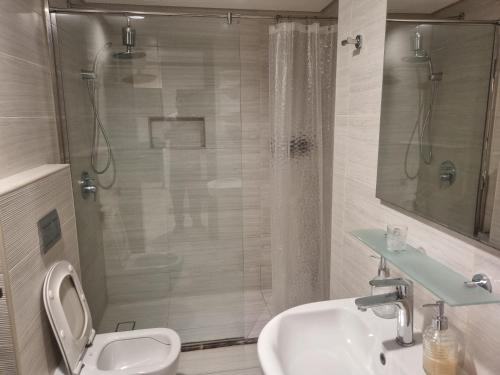 a bathroom with a shower and a toilet and a sink at Sea View Apartment in Era View in Manama