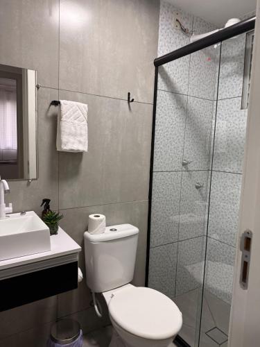 a bathroom with a toilet and a glass shower at Spazio Cristalli Comfort in Cuiabá