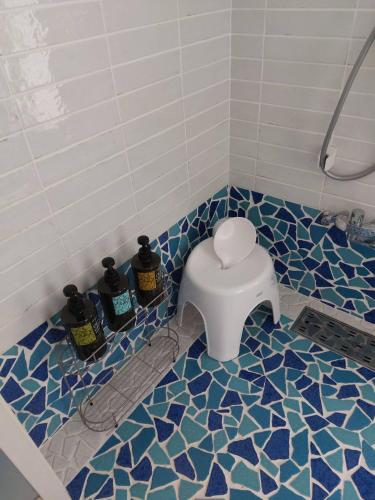 a bathroom with a toilet in a blue and white tiled floor at Sea Shell Kawazu House in Kawazu