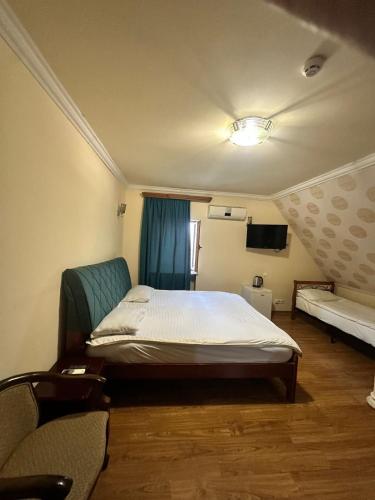 a bedroom with a bed and a couch and a television at DAVID Hotel in Yerevan
