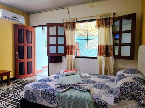 a bedroom with a bed and a window with curtains at Hotel Alto Amazonas in Leticia