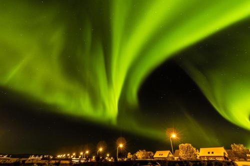 an image of the northern lights in the sky at Eyvindarholt Guesthouse in Álftanes