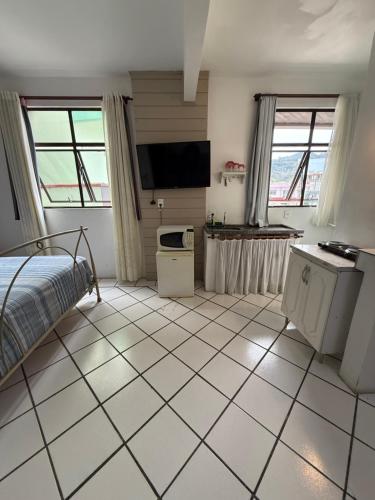 a bedroom with a bed and a tiled floor at KITNETS Kretzer Hinckel 2 - CENTRO in Alfredo Wagner
