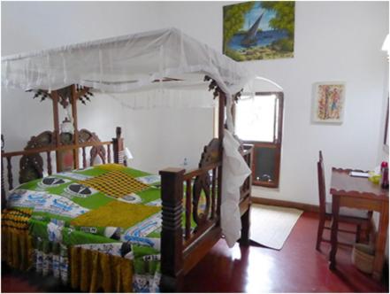 a bedroom with a bed with a canopy at The Old Boma Hotel in Mtwara