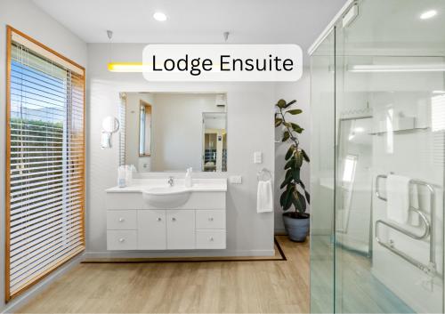 a bathroom with a white sink and a shower at Vibrant Living Retreat in Hanmer Springs