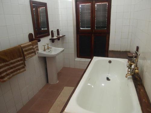 a bathroom with a bath tub and a sink at The Old Boma Hotel in Mtwara
