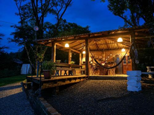 a wooden pavilion with a hammock in it at night at Chalé Pé da Serra in Treviso
