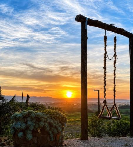 a sunset with a libellary hanging from a pole at Chalé Pé da Serra in Treviso