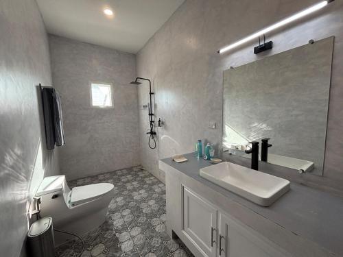 a bathroom with a sink and a toilet and a mirror at Duplex Villa 1 in Trat