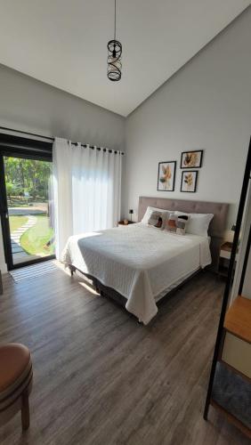 a bedroom with a large bed and a large window at Villa Pomerode Hospedagem - Suítes com conforto e aconchego conectados com a Natureza in Pomerode