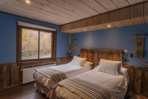 a bedroom with two beds and a window at VT Coffee & Lodge in Curarrehue