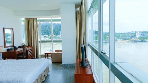 a bedroom with a bed and a view of the water at River Hotel in Hà Tiên