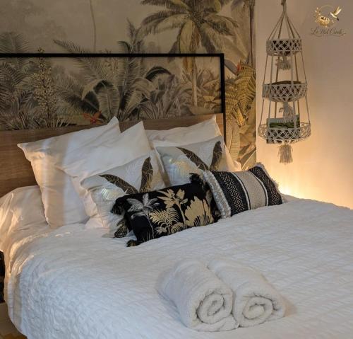 a bedroom with a bed with towels on it at Le Nid Créole in Belle-Allée