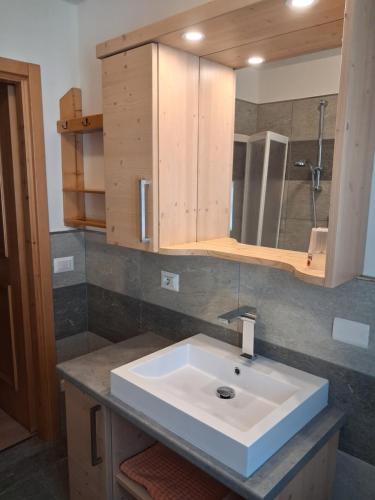 a bathroom with a white sink and a mirror at Chalet Bianco in Valdidentro