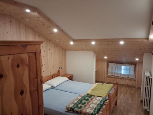 a bedroom with a bed in a wooden cabin at Chalet Bianco in Valdidentro