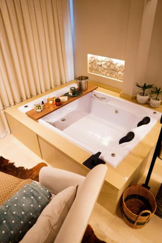 a large bath tub in a room with a couch at Moldavite Bungalow in Treze Tílias