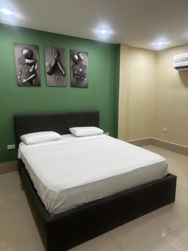 a bed in a room with four pictures on the wall at La Rosita 2 in Puerto Colombia