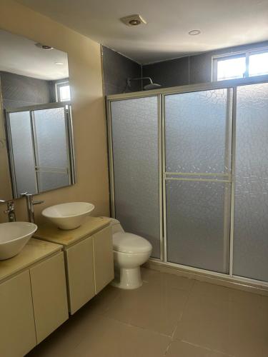 a bathroom with two sinks and a toilet and a shower at La Rosita 2 in Puerto Colombia