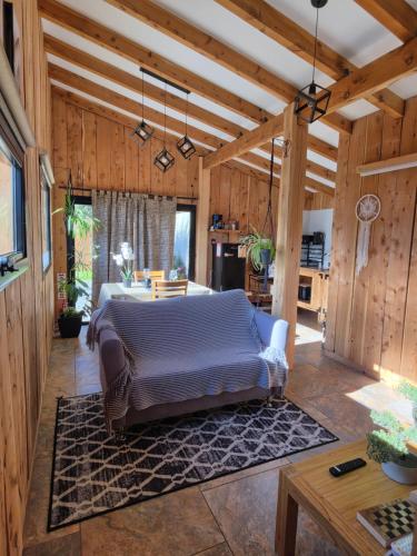 a bedroom with a bed in a room with wooden walls at Cabañas Dos Maitenes in Villa Traful