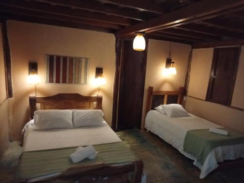 a hotel room with two beds and two tables at A-típico in Santa Marta