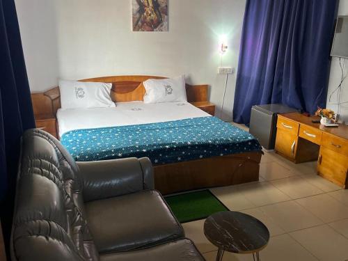 una camera da letto con un letto, una sedia e una scrivania di Hotel Caledonian a Chantan