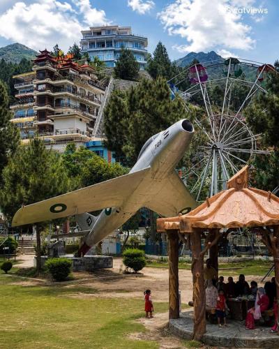a model of a plane in a park with a ferris wheel at Galiyat City hotel in Mingāora