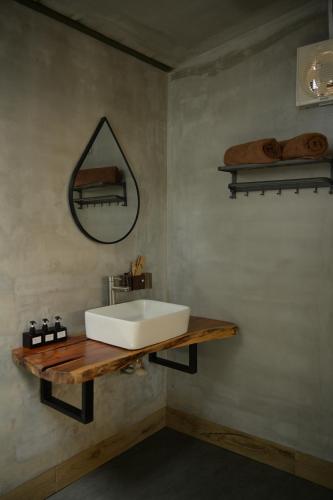 a bathroom with a white sink on a wooden shelf at Nọng Villa in Phan Thiet