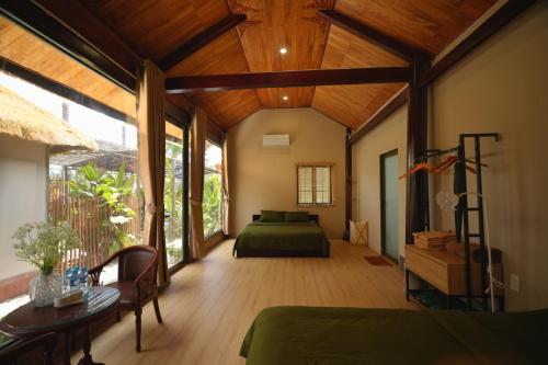 a bedroom with a green bed and wooden ceilings at Nọng Villa in Phan Thiet