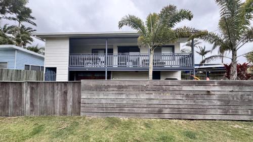 a house with a wooden fence in front of it at JJ s Holiday House in Wooli
