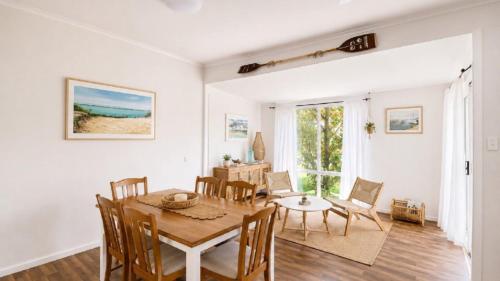 a dining room and living room with a table and chairs at Surfside in Wooli