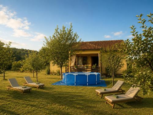 a yard with a pool and chairs and a house at Green Little Cottage with Pool near Ostrog Monastery in Danilovgrad