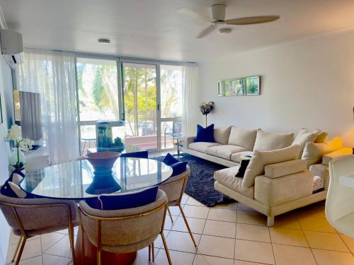 a living room with a glass table and a couch at Noosa Luxury Apartment in Noosa Heads